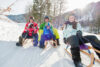 Familie rodelt im Schnee