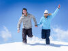 glückliches Paar im Schnee laufen