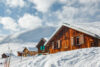 Schneebedeckte Chalets in den Schweizer Alpen, direkt an der Piste