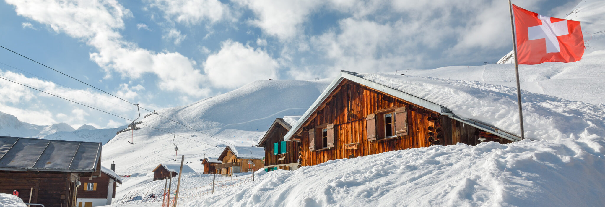 Schneebedeckte Chalets in den Schweizer Alpen, direkt an der Piste